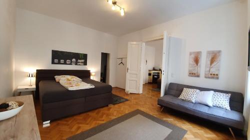 a living room with a bed and a couch at Gorgeous Viennese Apartment 10 min to City Center in Vienna