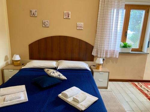 1 dormitorio con 1 cama azul y 2 toallas en b&b Casa di Antonio_Etna Vacanze, en Trecastagni
