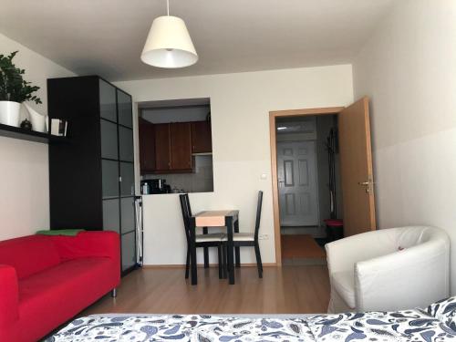 ブダペストにあるCozy Apartment in District 8のリビングルーム(赤いソファ、テーブル付)