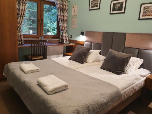 a bedroom with two beds with towels on them at Chata nad Sztolnią in Bystrzyca Górna