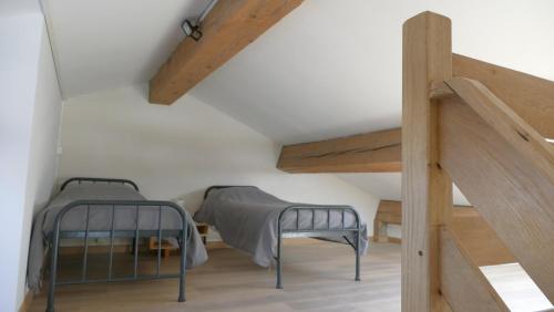una camera con due letti e una scala in legno di Domaine du Grand Arc : le Loft a Cucugnan