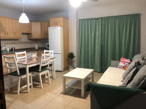 a kitchen and living room with a table and a refrigerator at LAS CALMAS in La Restinga