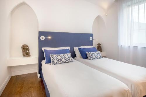 1 cama con cabecero azul y almohadas en Luxury Apartment with Penthouse and Pool, en Sant'Agnello