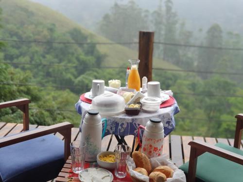 una mesa con comida y vistas en Cabana Vista Maravilhosa, en Visconde De Maua