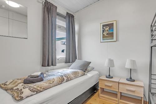 a white bedroom with a bed and a window at Guesthouse Vatnsholt in Vatnsholt