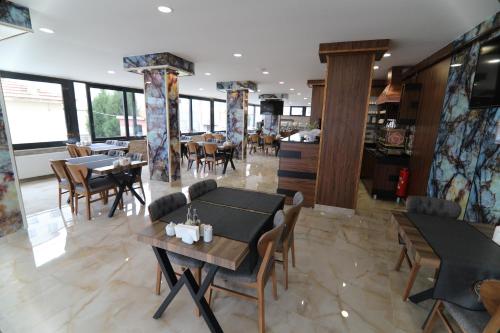 un comedor con mesas y sillas en un restaurante en Marbes HOTEL, en Kırklareli