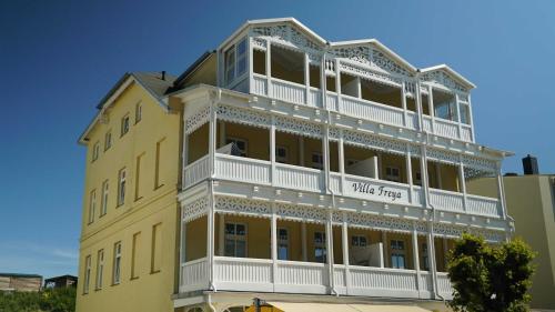 - un bâtiment jaune avec des balcons blancs sur le côté dans l'établissement Ferienwohnung mit Balkon in Baeder, à Sellin