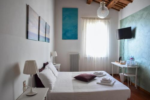 a bedroom with a bed and a table and a window at La casa di Pilar in Cotignola