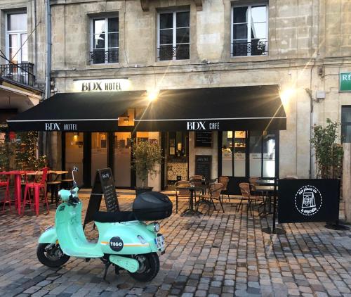 un scooter bleu garé devant un restaurant dans l'établissement BDX Hôtel - Gare Saint-Jean, à Bordeaux