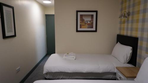 a room with two beds in a hotel room at Greenland's Inn in Longbridge