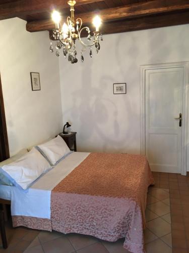um quarto com uma cama e um lustre em Il Cortile del Castello em Capena