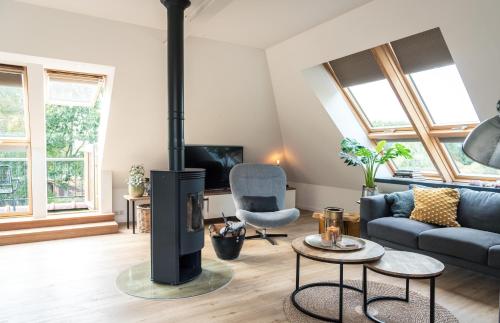 a living room with a couch and a fireplace at Loft 8 Linden in Groot-Linden