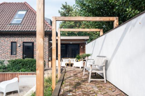 a backyard patio with a wooden pergola at Loft 8 Linden in Groot-Linden