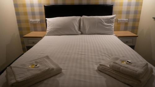 a bed with two towels and two pillows on it at Greenland's Inn in Longbridge