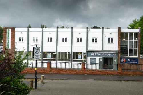 a white building with a sign in front of it at Greenland's Inn in Longbridge