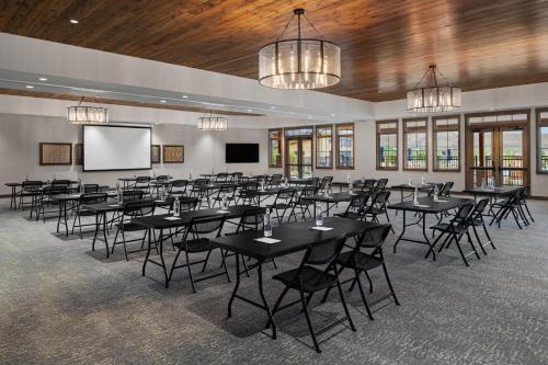 a conference room with tables and chairs and a screen at Sun Outdoors Rocky Mountains in Granby