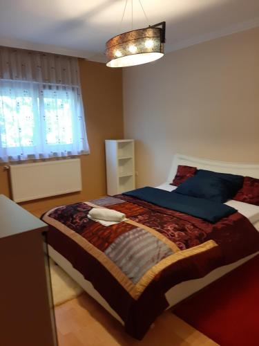 a bedroom with a bed with blue pillows and a window at Villa Csilla elegant house in Érd