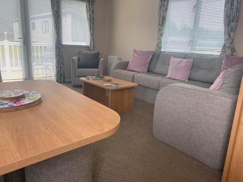 uma sala de estar com um sofá e uma mesa em Glenholme Retreat em Newton on the Moor