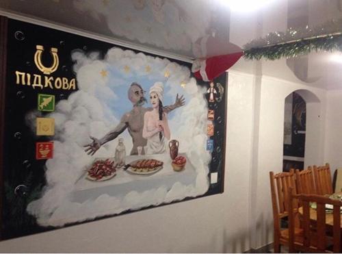 a painting of a man and a woman on a wall at Садиба 2 Підкова чан та сауна in Pistyn
