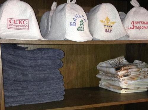 a shelf with white towels and a pile of towels at Садиба 2 Підкова чан та сауна in Pistyn