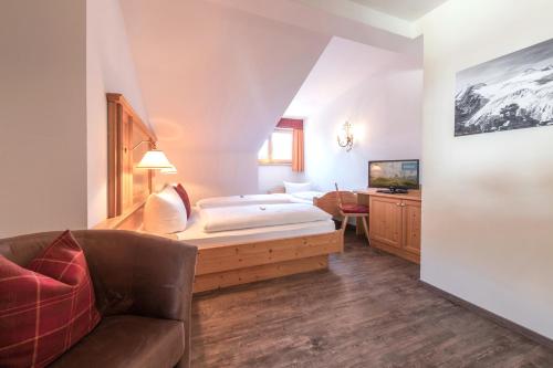 een hotelkamer met een bed en een bank bij Bruggerhof in Fulpmes