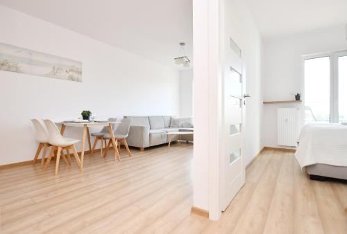 un soggiorno bianco con tavolo e divano di Apartament Solna C506 a Kołobrzeg