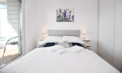 una camera bianca con un grande letto con due cuscini di Apartament Solna C506 a Kołobrzeg
