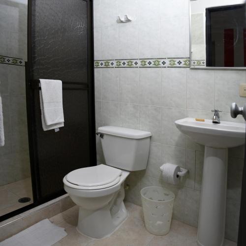 a bathroom with a toilet and a sink at Hotel Nova Park in Arauca
