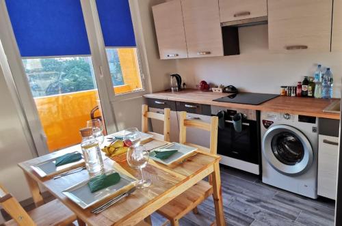 a kitchen with a table and a kitchen with a washing machine at Apartament Highway To Hel in Hel