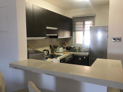 a kitchen with black cabinets and a stainless steel refrigerator at Anarita Townhouse in Anarita