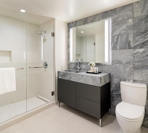 a bathroom with a toilet and a sink and a shower at AKA West Hollywood, Serviced Apartment Residences in Los Angeles