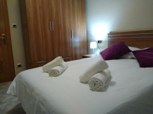 a bedroom with a white bed with towels on it at Apartamentos La Rosa - Calamocha in Calamocha