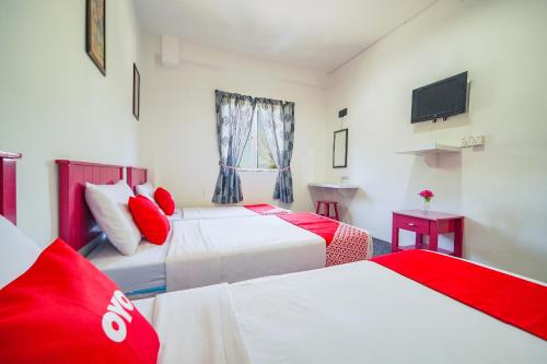 Cette chambre comprend deux lits et une télévision. dans l'établissement OYO 89710 Saujana CT View Hotel, à Sungai Petani