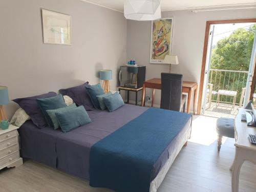 a bedroom with a large bed with blue pillows at Chambres d'Hôtes Le Vignaud in Brantôme