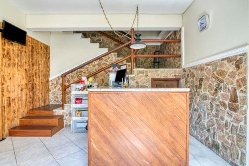 a kitchen with a wooden door and a stone wall at Pousada Danitato e lavanderia in Bom Jardim