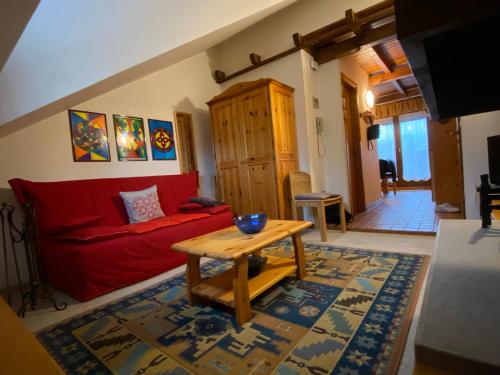 加廖的住宿－Appartamento a Gallio con vista sul Sacello，客厅配有红色的沙发和桌子