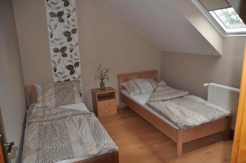 2 camas en una habitación pequeña con ventana en Győrszem Apartman, en Győr