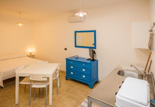a kitchen and dining room with a table and a blue cabinet at On the Beach in Torre Lapillo
