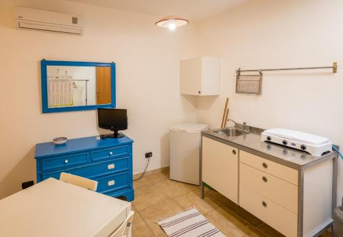 uma cozinha com um lavatório e um armário azul em On the beach em Torre Lapillo
