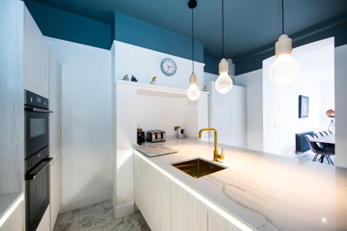 a kitchen with blue ceilings and a sink and a counter at Rounton Villa by Maison Parfaite - Hot Tub - Sea Views - Parking in Robin Hood's Bay