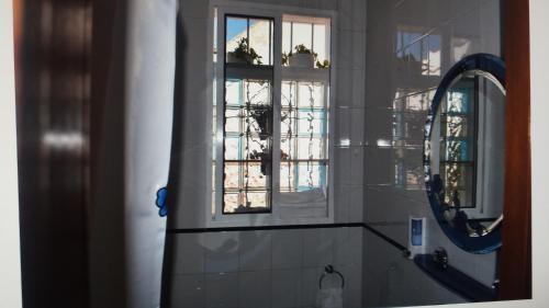 a bathroom with a mirror and a sink and a window at La Casa Malagueña. in Málaga