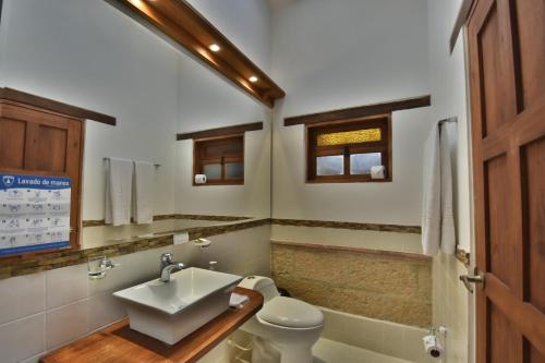 a bathroom with a sink and a toilet at Hotel Jardines De La Villa in Villa de Leyva