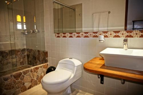 a bathroom with a toilet and a sink at Hotel Jardines De La Villa in Villa de Leyva
