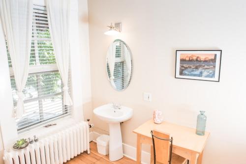 een badkamer met een wastafel, een tafel en een spiegel bij Dancing Bear Inn Hostel in Nelson