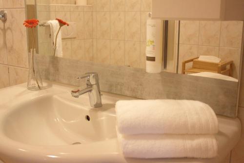 a white bathroom sink with towels on it at Pension Lammerhof in Unterlamm
