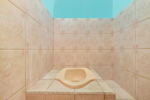 uma casa de banho com um urinol numa parede de azulejos em OYO 2384 Pondok Nabil em Cileunyi