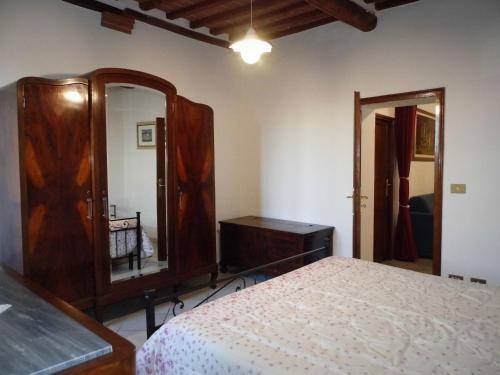 een slaapkamer met een bed, een dressoir en een spiegel bij CASA SERENA in Montepulciano