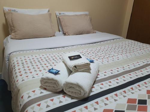 a bed with towels and pillows on it at Pousada Quatro Estações in Alto Paraíso de Goiás