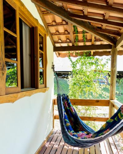 a hammock on the porch of a house at Chalés do Pardal in Visconde De Maua