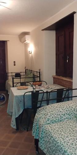 una camera con due letti e un tavolo in una stanza di Villa Diana a Fiumefreddo di Sicilia